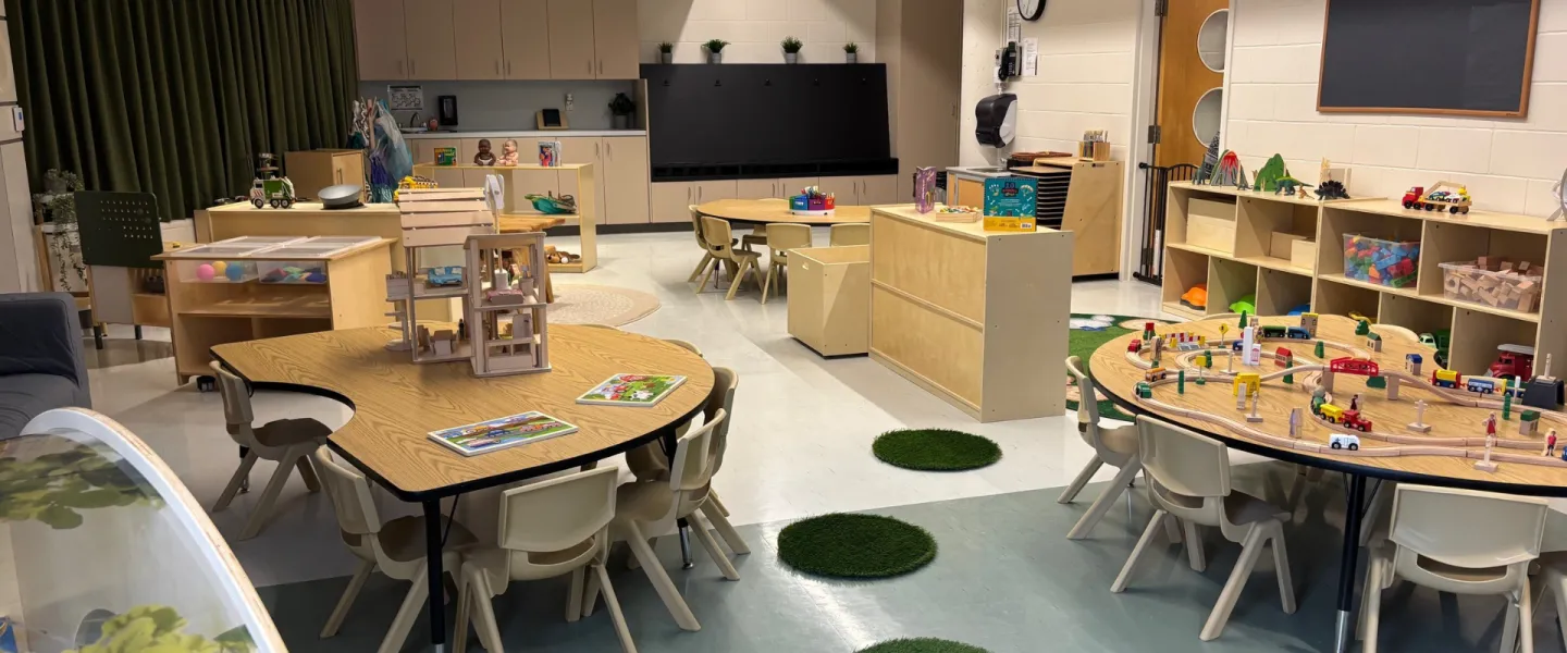 Churchill Child Care Centre interior. There are small chairs, tables, and toys.