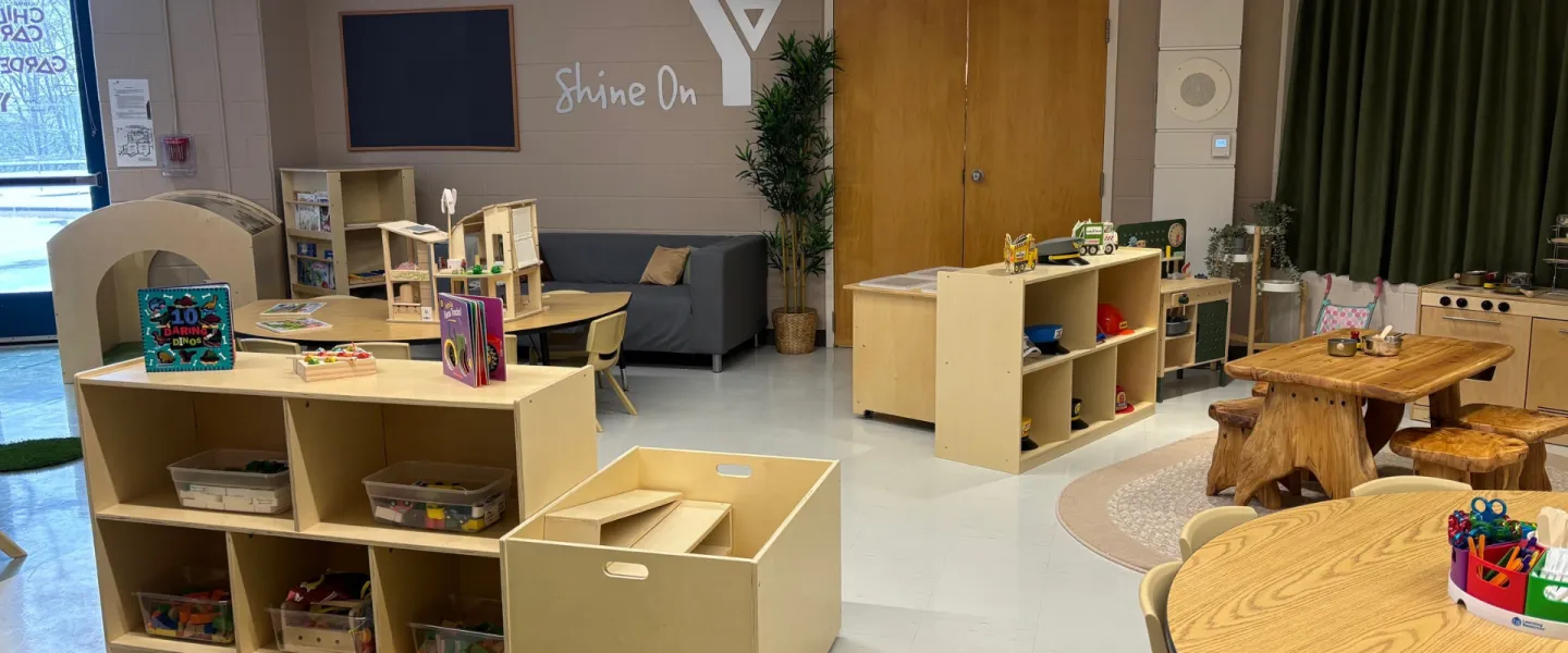 Churchill Child Care Centre interior. There are small chairs and tables, as well as shelves, toys, and decorations.