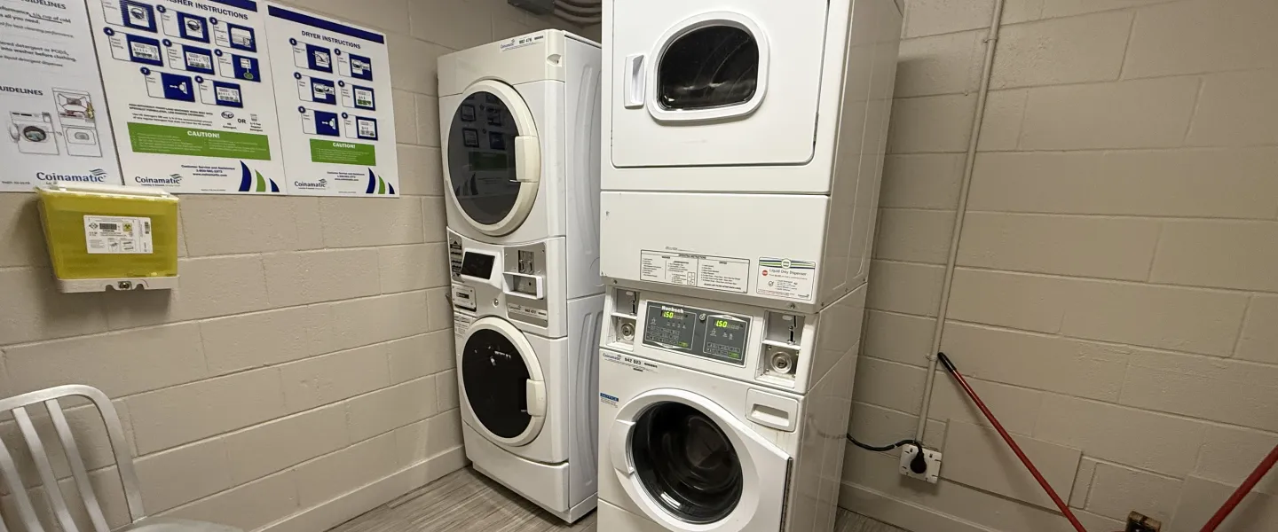 A laundry room with two washers and two dryers