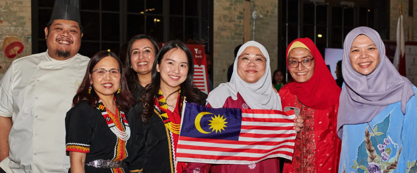 A group photo of folks from the High Commission of Malaysia. They are holding a Malaysian flag.