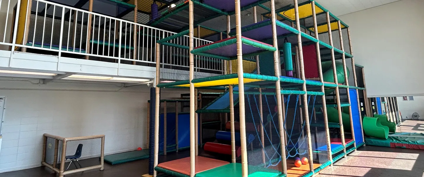 A colorful indoor play area featuring a slide and a climbing area for children to enjoy activities.