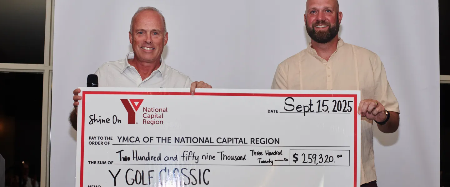 Two people holding a large cheque to the YMCA of the National Capital Region for $259,320.