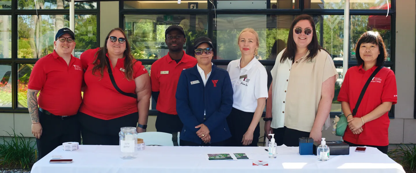 A group of seven Y staff at an outdoor booth