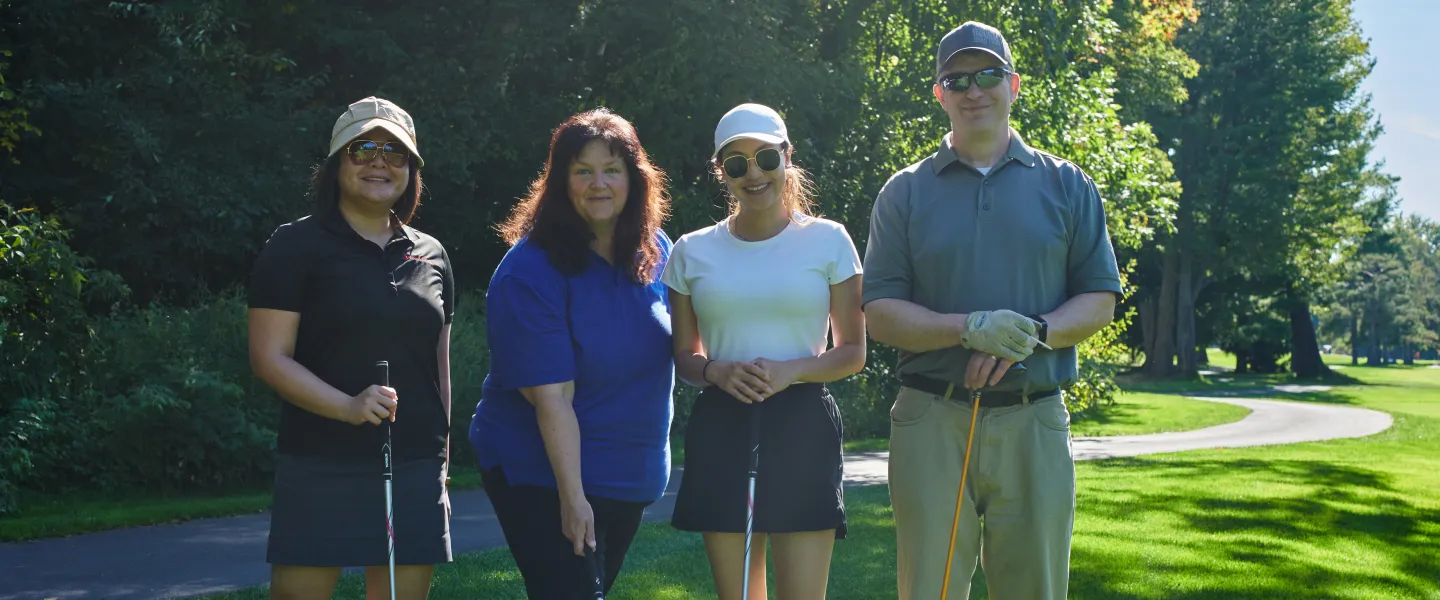 Four golfers standing together on a golf course