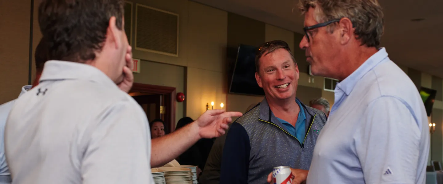 Four people chatting at an indoor reception