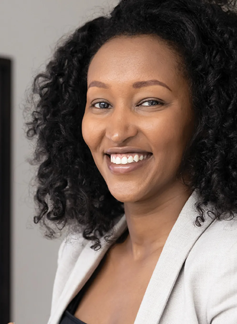 A woman stands holding a tablet in front of a whiteboard, engaged in a presentation or discussion.