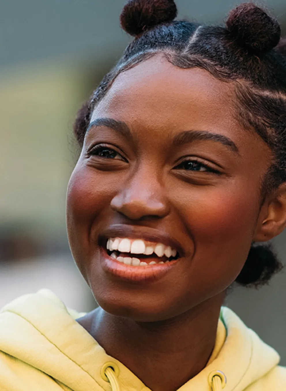 A young woman smiles while engaging in conversation.