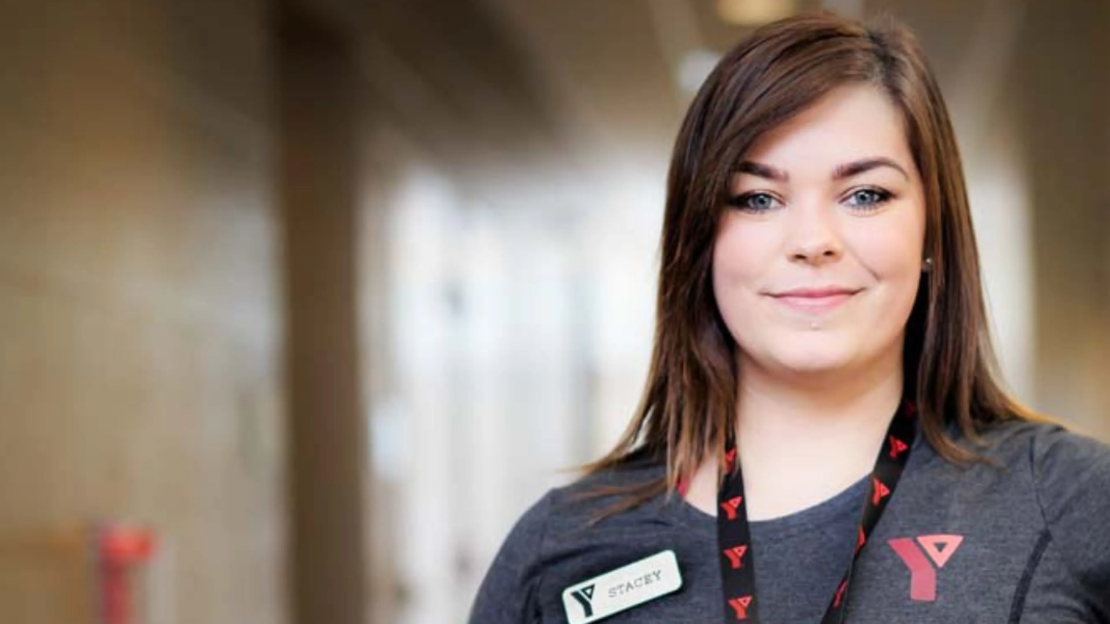 Female Y staff person smiles at camera.