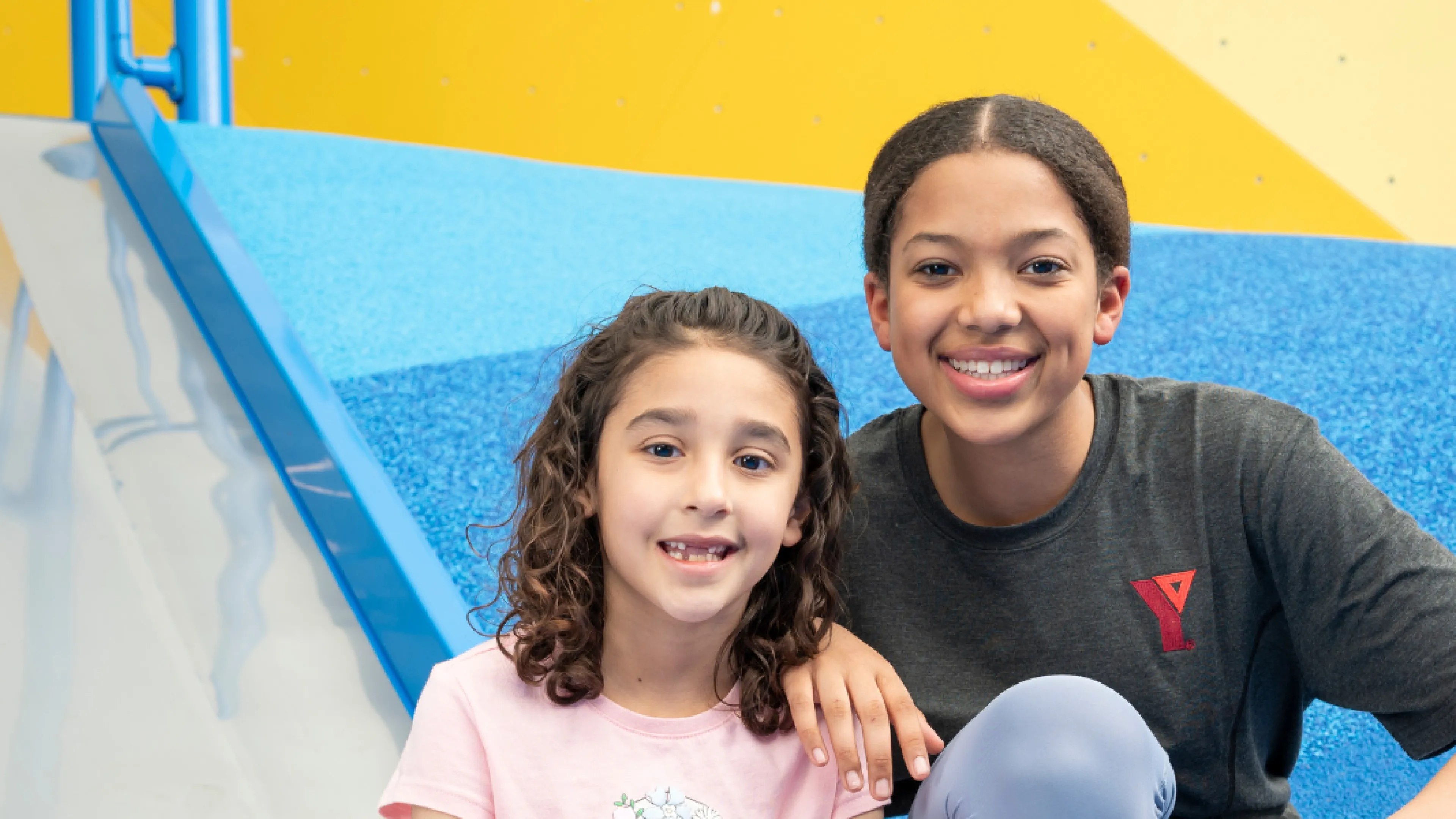 Y staff and child smile at camera.