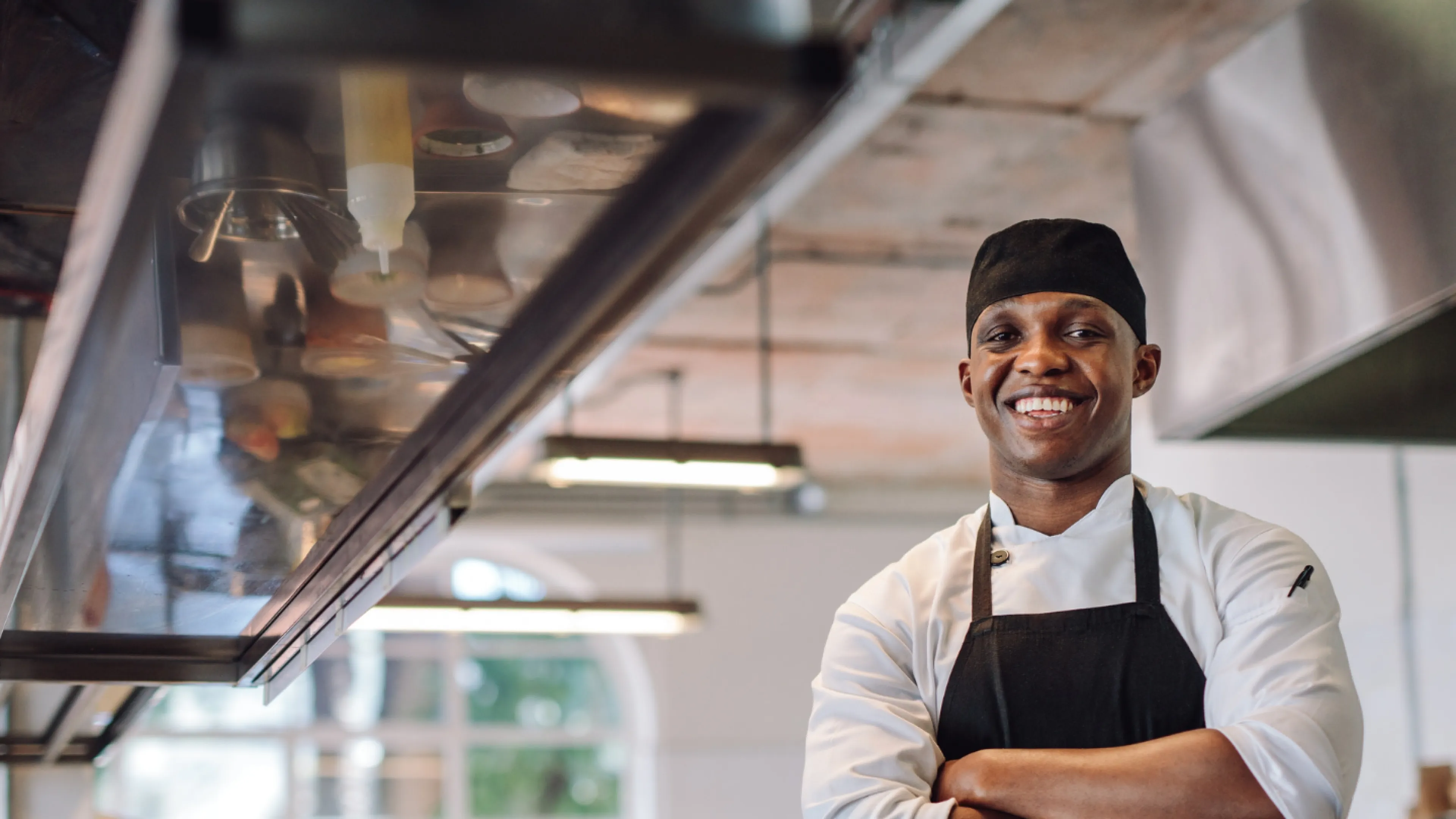 A chef smiling with his arms crossed
