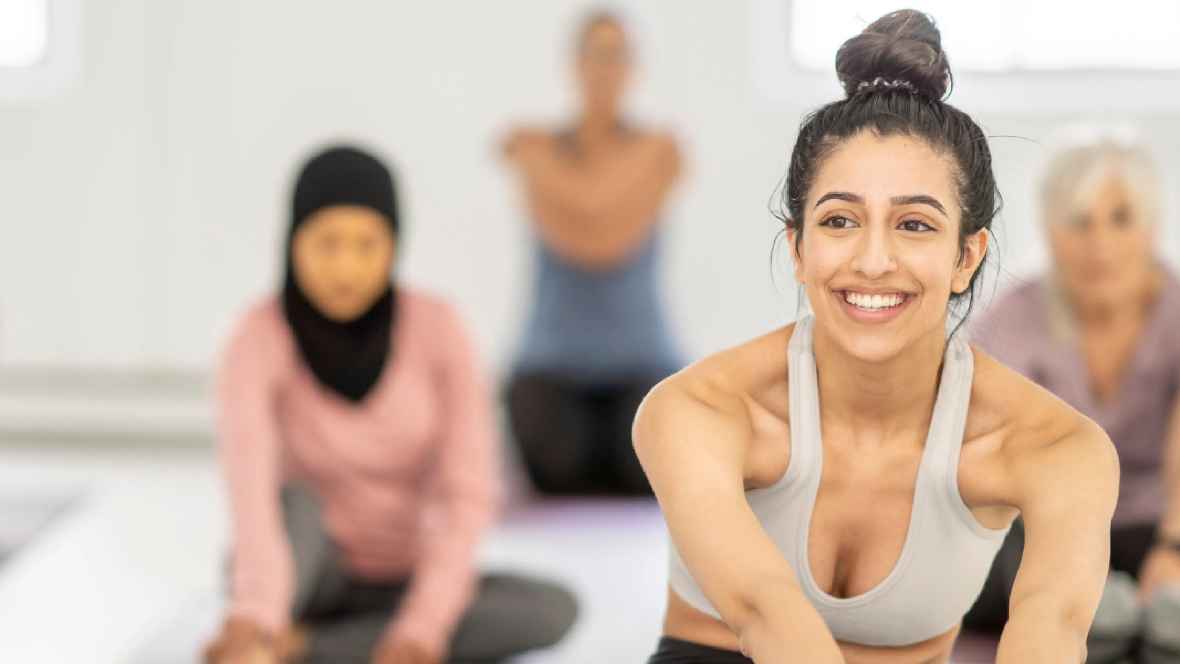 A woman smiles in a group fitness class.