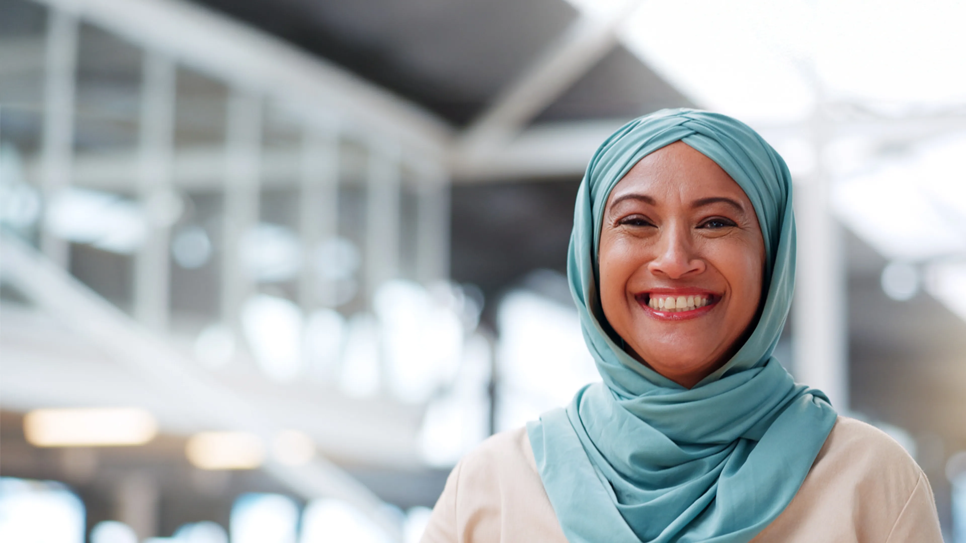 A smiling woman wearing a hijab.