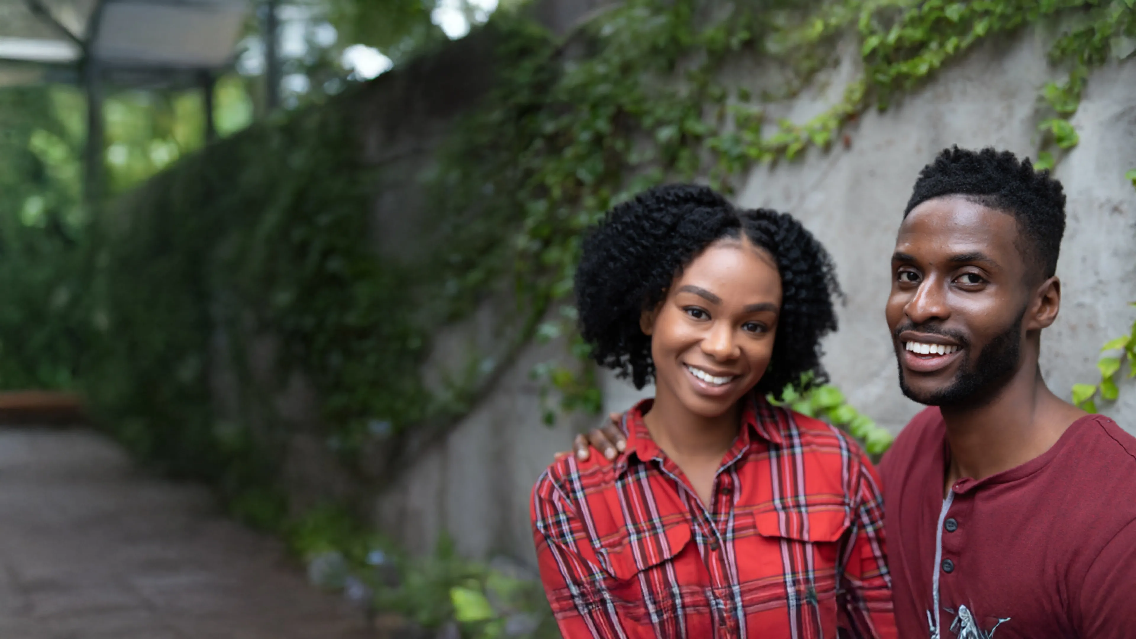 man and woman outdoors smile at camera