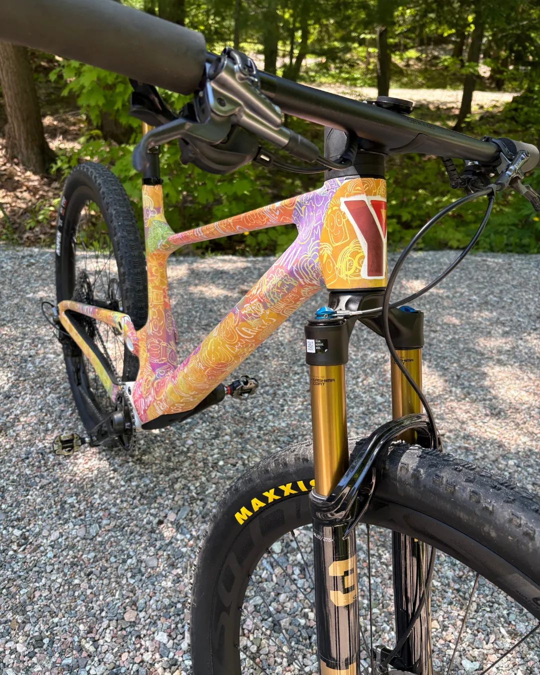 Morgan's orange, pink and white bike on a forest path. The Y logo is displayed on the front.
